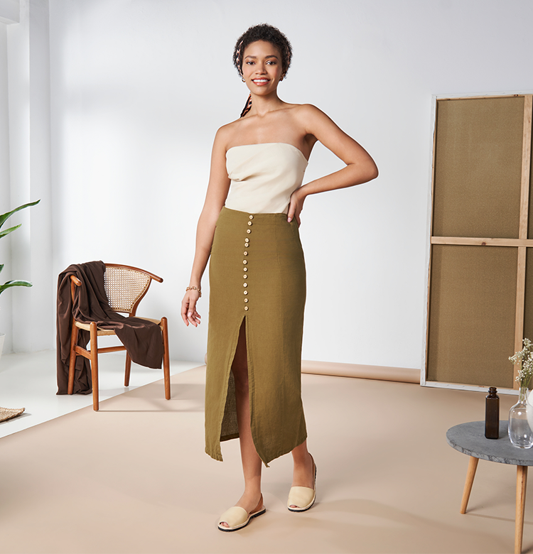 Woman wearing a cream top with an olive long skirt paired with Viscata's Menorquina leather avarcas