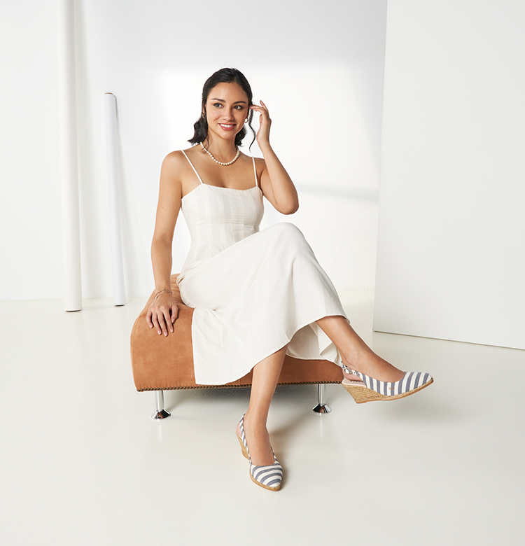 Woman sitting down wearing a white dress paired with Viscata's Palomera sailor stripe slingback espadrilles